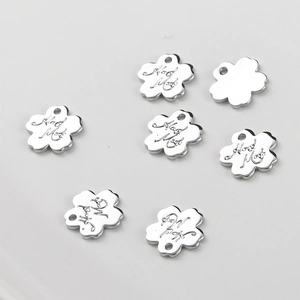 Detailed macro of flower-shaped charms with Hand Made engraving for jewelry DIY