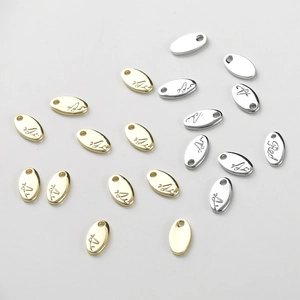 Macro detail of oval gold and silver pendant tags with Red engraving for DIY jewelry