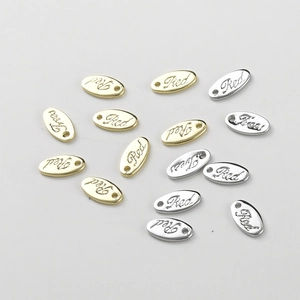 Macro shot of oval gold and silver metal tags with Red engraving for DIY jewelry making