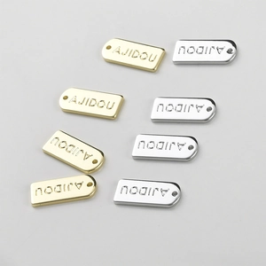Macro detail of 14k gold and silver plated rectangular letter charms for DIY jewelry