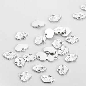 Macro view of scattered silver heart charms with Love engraving for DIY jewelry