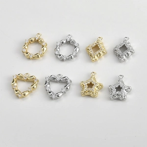 Close-up of 14k gold plated heart star and geometric charms with inlaid zircon stones