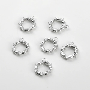 Close-up of six silver-plated round pendants with inlaid cubic zirconia for DIY jewelry