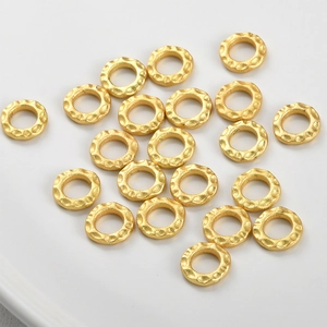Golden hammered hollow round spacer beads for DIY jewelry making on white tray