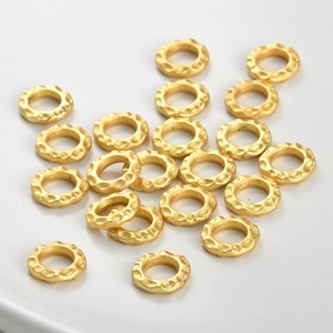 Macro shot of gold hammer textured spacer beads for DIY jewelry making and necklaces