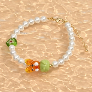 Incantevole bracciale di perle con coniglio di vetro arancione e ciondolo a fiore verde