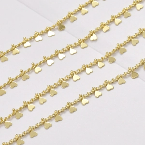 Détail macro d'une chaîne torsadée plaquée or 14 carats avec pendentifs cœurs pour bijoux