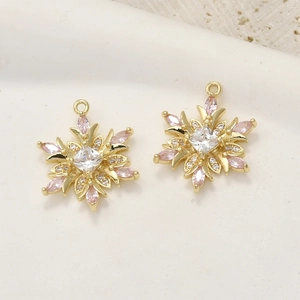 Detail of 14k gold plated snowflake charms with pink zircon and white diamond accents