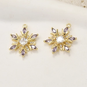 Detail of 14k gold plated snowflake pendants with purple and white zircon crystals