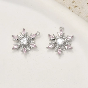 Detailed macro view of 14k gold plated snowflake pendants with pink and white cubic zirconia