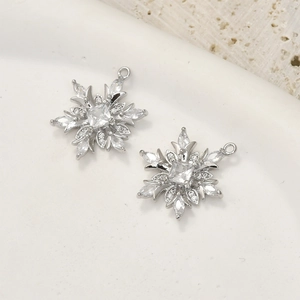 Macro view of 14k gold plated silver snowflake charms with inlaid cubic zirconia stones