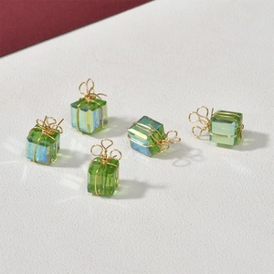 Detailansicht grüner Kristall-Weihnachtsgeschenk-Anhänger mit Golddraht für DIY-Schmuck