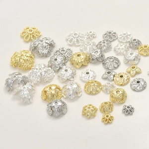 Dettaglio macro di copriperle a fiore placcati oro 14k e distanziatori per gioielli DIY