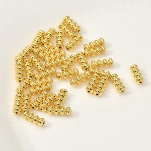 Detalle macro de cuentas espaciadoras de linterna bañadas en oro de 14k para joyería DIY