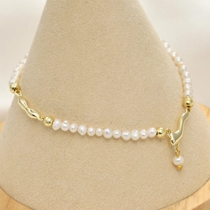 Close-up of 14k gold plated irregular metal parts and white pearls for DIY bracelets