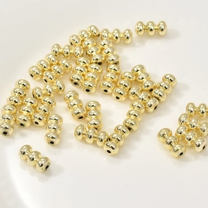 Primer plano de cuentas espaciadoras de triple linterna en oro de 14k para joyería DIY