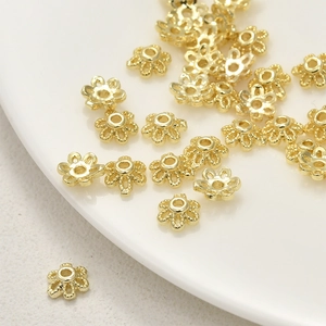 Dettaglio macro di copriperle a forma di fiore dorato per accessori gioielli fai-da-te
