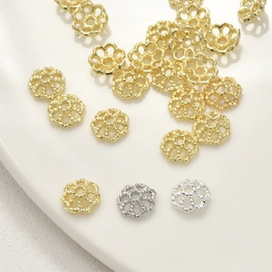 Dettaglio di copriperla a fiore traforati in oro e argento per creazione gioielli fai-da-te