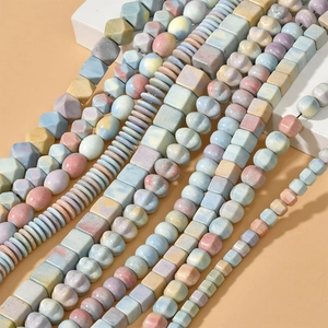 Macro view of macaron-colored rainbow stone beads in cube and pumpkin shapes for DIY jewelry