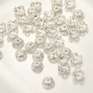 Dettaglio macro di distanziatori per perle in argento e copriperle per gioielli fai-da-te