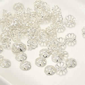 Dettaglio macro di copriperle a fiore argentati per accessori gioielli fai-da-te