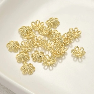 Dettaglio di distanziatori a fiore placcati oro 14k con trama a spirale per gioielli DIY