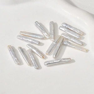Set of 15 natural baroque stick pearls with iridescent luster on a white plate