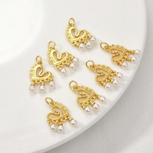 Detail view of heart-shaped gold-plated charms with small pearls for jewelry DIY