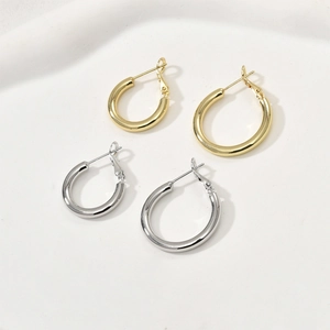 Créoles plaquées or 14 carats et argent de différentes tailles sur fond beige