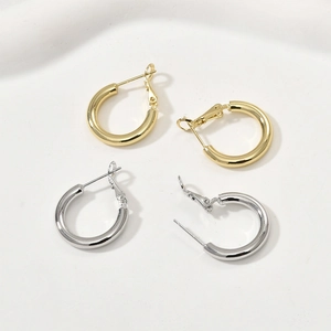 Créoles polies en or 14k et argent sur un plateau en céramique minimaliste