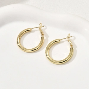 Vue détaillée de boucles d'oreilles créoles épaisses plaquées or 14k avec fini lisse