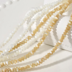 Macro detail of 3x5mm natural white shell abacus beads with glossy pearlescent finish