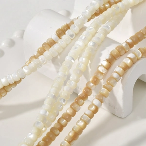 Macro view of natural shell wheel beads in creamy white and light brown for DIY jewelry