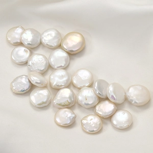 Macro shot of natural baroque freshwater pearls with flat round shape on white satin