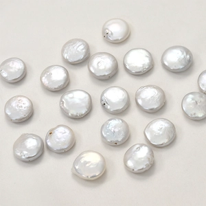 Macro shot of flat round natural freshwater pearls with visible drill holes for DIY jewelry