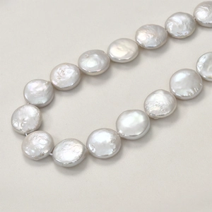 Macro shot of silver-white natural baroque coin pearls with glossy luster for DIY jewelry