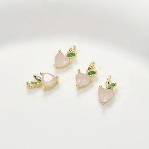Detail of peach-shaped pendant with pink stone, green leaves, and 14k gold-plated finish
