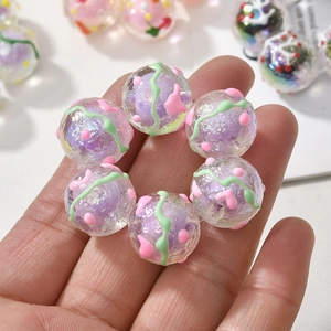 Detailansicht bunter Acrylperlen mit grünen Wellenmustern und rosa Punkten für DIY-Schmuck