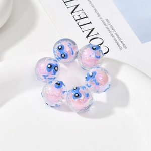 Makroaufnahme von 6 rosa Glitzer-Acrylperlen mit blauem Augenmuster für Schmuck