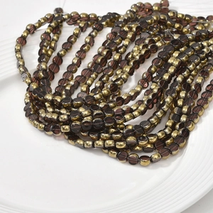 Detail of 6mm gold-plated crystal glass beads for DIY jewelry making in a ceramic dish