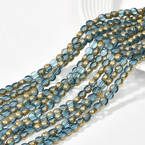Macro detail of 6mm flat round crystal glass beads with gold plating and blue finish