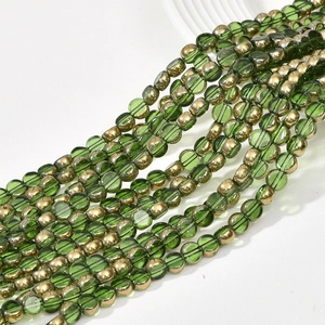Macro shot of 6mm dark green translucent glass beads with gold coating for jewelry making