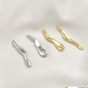 Close-up of wavy gold and silver plated metal charms for DIY jewelry making