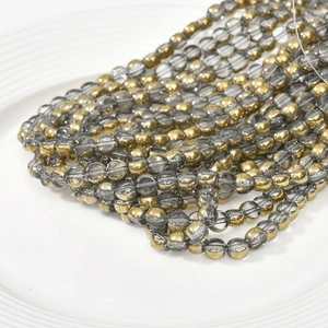 Macro shot of 6mm smoke gray glass beads and gold plated spacer beads for DIY jewelry making