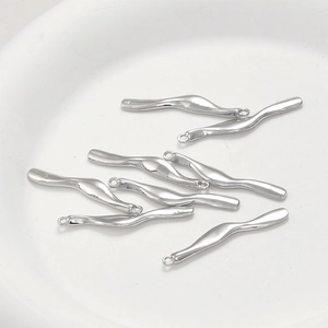 Macro shot of silver wavy metal pendants with loops for DIY jewelry making