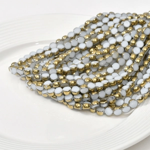 Detailed macro view of 6mm flat round crystal glass beads with gold plated edges