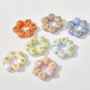 Detailed view of colorful ceramic cat paw beads with gold accents for DIY jewelry making