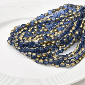 Macro shot of 6mm dark blue crystal glass beads with gold plated edges for DIY jewelry making
