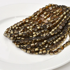 Macro shot of 6mm amber and gold dual-tone flat round glass beads for jewelry DIY