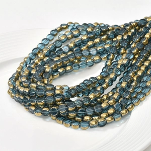 Macro detail of 6mm blue crystal glass beads with gold plated edges for DIY jewelry making